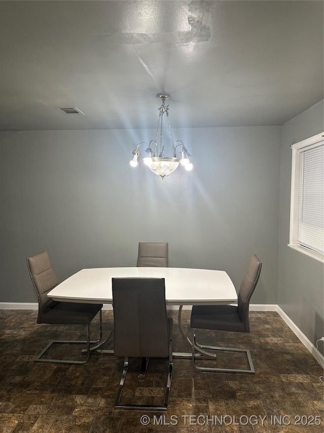 dining area featuring baseboards and a chandelier