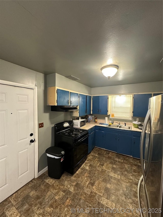 kitchen with blue cabinets, freestanding refrigerator, black range with gas stovetop, and white microwave