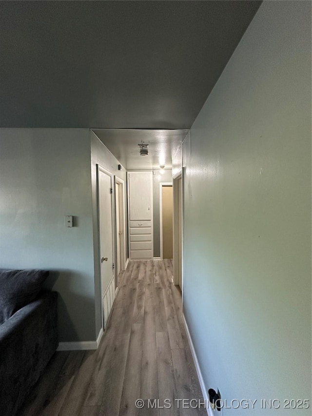 hall with light wood finished floors and baseboards