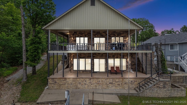 441 Ramey St, Eucha, OK 74342 - back of property at dusk featuring stairway, a patio, a deck, and board and batten siding