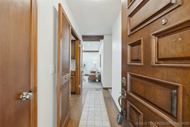 entrance foyer with a textured ceiling and light tile patterned flooring