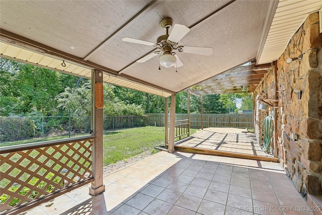 view of patio featuring ceiling fan and view of scattered trees