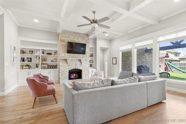 12113 S Fulton Ave E, Bixby, OK 74008 - living area with light wood finished floors, a stone fireplace, ceiling fan, coffered ceiling, and baseboards