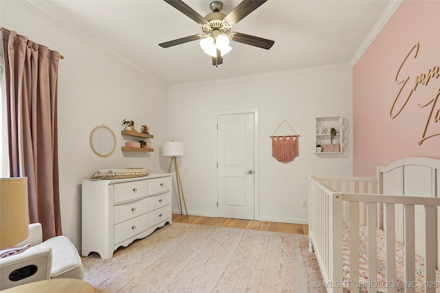 12113 S Fulton Ave E, Bixby, OK 74008 - bedroom with light wood-type flooring, a crib, crown molding, a ceiling fan, and baseboards