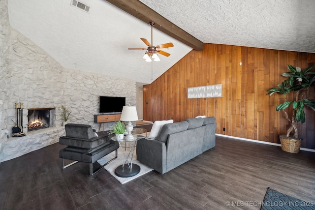 6505 E 47th St, Tulsa, OK 74145 - living room with ceiling fan, a fireplace, wood finished floors, wooden walls, and a textured ceiling