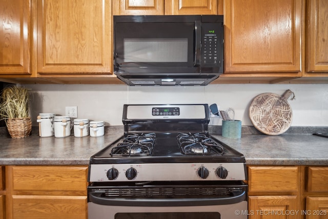 6505 E 47th St, Tulsa, OK 74145 - kitchen featuring stainless steel range with gas cooktop, black microwave, and dark countertops