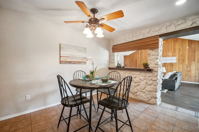 6505 E 47th St, Tulsa, OK 74145 - dining room featuring ceiling fan, tile patterned flooring, baseboards, and wooden walls
