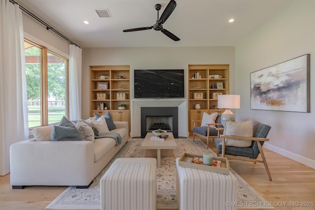 6407 N Blue Sage Dr, Owasso, OK 74055 - living area featuring light wood-style flooring, a fireplace, recessed lighting, and built in features