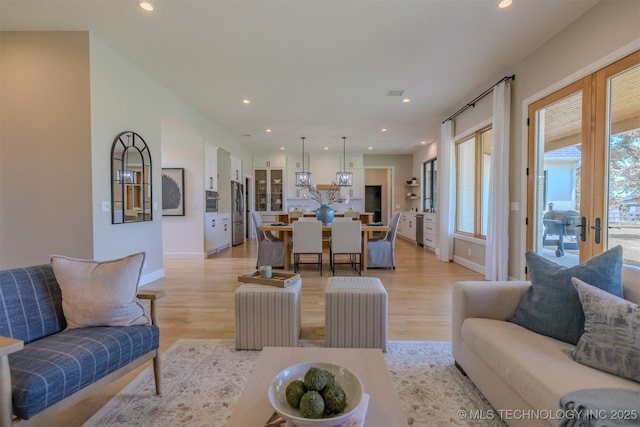 6407 N Blue Sage Dr, Owasso, OK 74055 - living area featuring recessed lighting, light wood finished floors, french doors, baseboards, and a chandelier