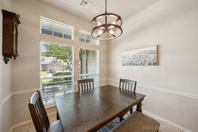 dining room with a chandelier, baseboards, and light tile patterned floors