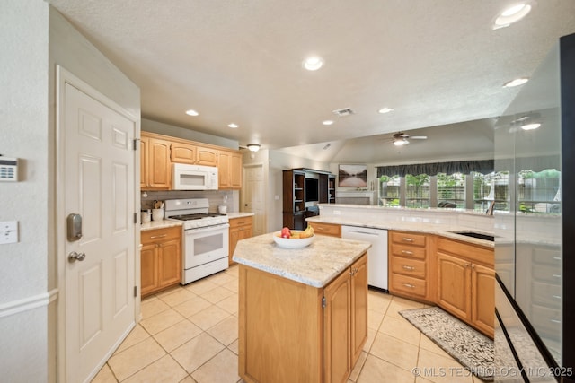 kitchen featuring white appliances, a kitchen island, light tile patterned flooring, tasteful backsplash, and light stone counters