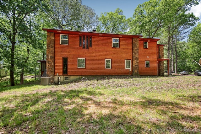 view of side of property featuring cooling unit and a lawn