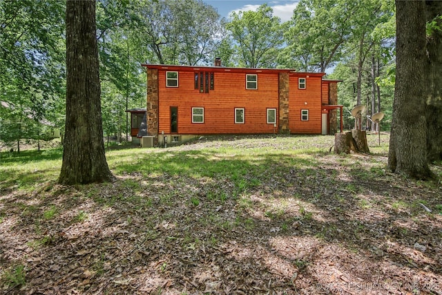 rear view of property with central AC and a chimney