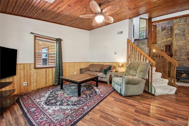 living area with wainscoting, plenty of natural light, stairway, wood finished floors, and wood ceiling
