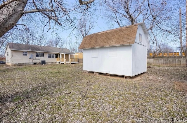 233 N 44th W Ave, Tulsa, OK 74127 - rear view of property featuring a shingled roof, a gambrel roof, an outdoor structure, a storage shed, and central AC unit