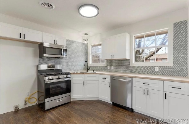 233 N 44th W Ave, Tulsa, OK 74127 - kitchen featuring stainless steel appliances, a sink, tasteful backsplash, white cabinets, and light countertops