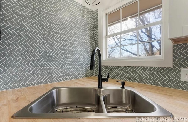 233 N 44th W Ave, Tulsa, OK 74127 - kitchen view of a sink, light countertops, decorative backsplash, and white cabinetry