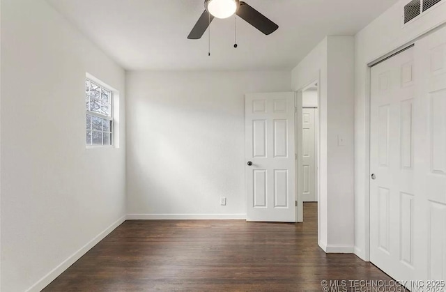 233 N 44th W Ave, Tulsa, OK 74127 - unfurnished bedroom with dark wood-style flooring, baseboards, a closet, and ceiling fan