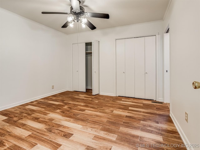 7446 E 20th St, Tulsa, OK 74112 - unfurnished bedroom with multiple closets, crown molding, light wood-style floors, and a ceiling fan
