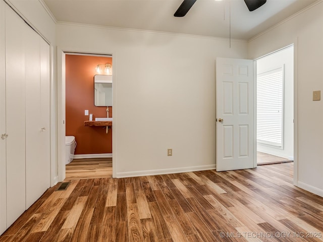 7446 E 20th St, Tulsa, OK 74112 - unfurnished bedroom with ornamental molding, wood finished floors, connected bathroom, and a ceiling fan