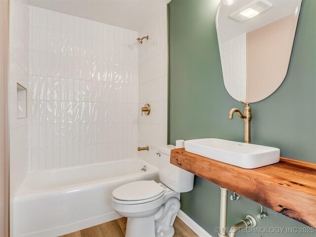 7446 E 20th St, Tulsa, OK 74112 - bathroom featuring wood finished floors and washtub / shower combination