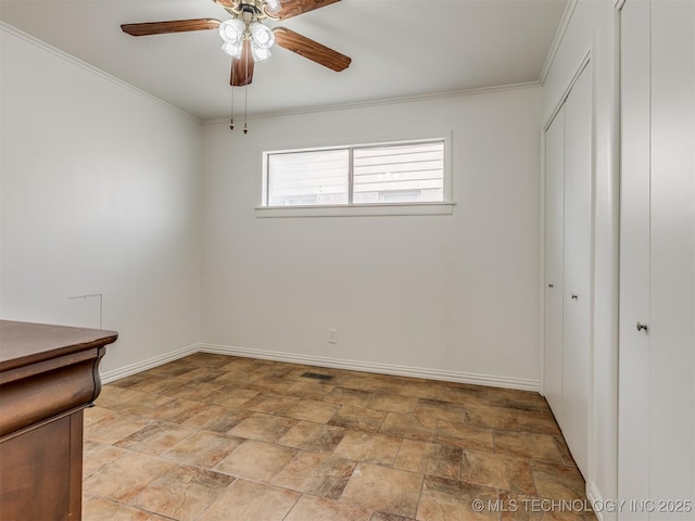 7446 E 20th St, Tulsa, OK 74112 - unfurnished bedroom with stone finish floors, a closet, baseboards, crown molding, and a ceiling fan