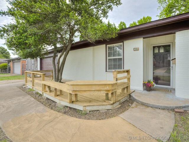 7446 E 20th St, Tulsa, OK 74112 - view of exterior entry featuring driveway and brick siding