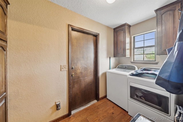 9599 E 155th Ave N, Owasso, OK 74055 - laundry area featuring washing machine and dryer, cabinet space, a textured wall, wood finished floors, and baseboards