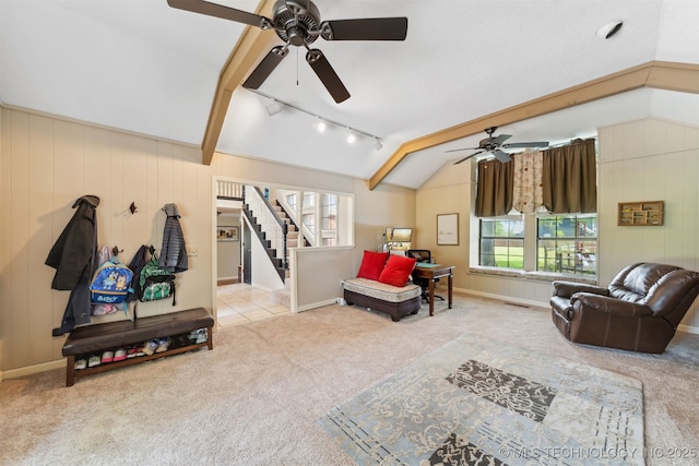 9599 E 155th Ave N, Owasso, OK 74055 - carpeted living area featuring a ceiling fan, healthy amount of natural light, rail lighting, stairs, and wooden walls