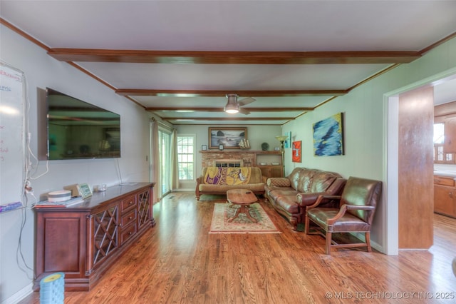 5102 S Columbia Ave, Tulsa, OK 74105 - living room featuring light wood-style floors, ceiling fan, plenty of natural light, beamed ceiling, and a brick fireplace
