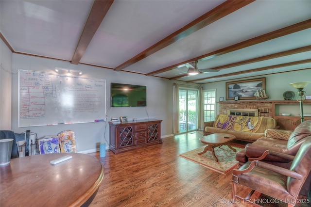 5102 S Columbia Ave, Tulsa, OK 74105 - living area with beamed ceiling, a ceiling fan, wood finished floors, baseboards, and a brick fireplace