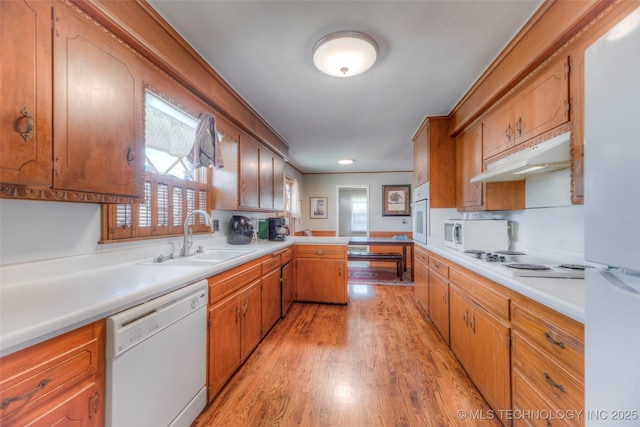 5102 S Columbia Ave, Tulsa, OK 74105 - kitchen featuring white appliances, a sink, light wood-style floors, a peninsula, and under cabinet range hood