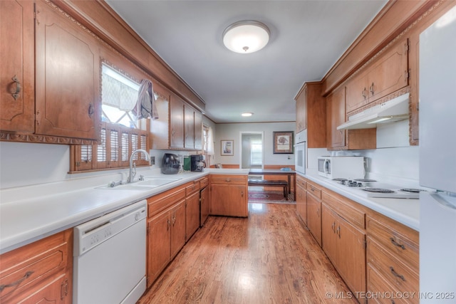 5102 S Columbia Ave, Tulsa, OK 74105 - kitchen featuring white appliances, light wood-style flooring, a peninsula, under cabinet range hood, and light countertops