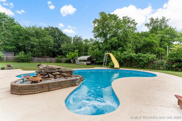 11815 S 86th E Ave, Bixby, OK 74008 - view of swimming pool featuring a water slide, a patio, an outbuilding, and view of scattered trees