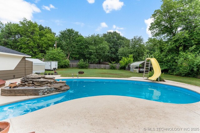11815 S 86th E Ave, Bixby, OK 74008 - view of swimming pool with a storage unit, an outbuilding, a water slide, a patio, and view of wooded area