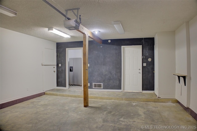 4601 S 66th Ave E, Tulsa, OK 74145 - garage with stainless steel fridge, a garage door opener, and baseboards
