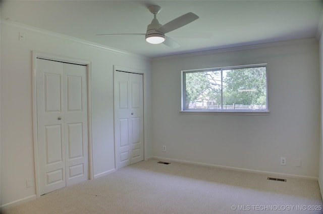 4601 S 66th Ave E, Tulsa, OK 74145 - unfurnished bedroom with ornamental molding, multiple closets, carpet flooring, ceiling fan, and baseboards