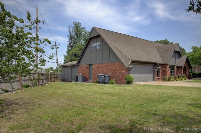 4601 S 66th Ave E, Tulsa, OK 74145 - view of side of property with brick siding, central AC, an attached garage, board and batten siding, and concrete driveway