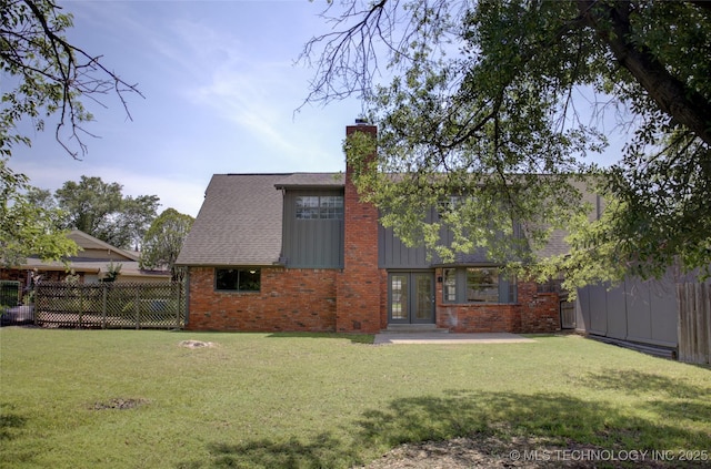 4601 S 66th Ave E, Tulsa, OK 74145 - back of house with brick siding, a chimney, a shingled roof, board and batten siding, and a patio