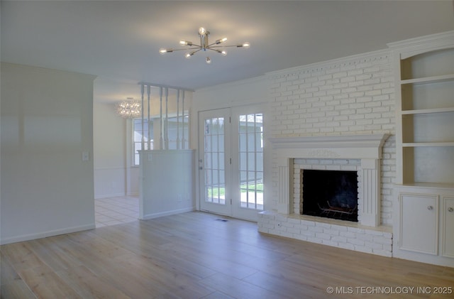 4601 S 66th Ave E, Tulsa, OK 74145 - unfurnished living room with a chandelier, a fireplace, wood finished floors, ornamental molding, and baseboards