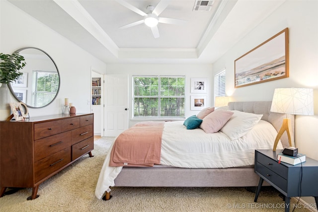 21304 S 4200th Rd, Claremore, OK 74019 - bedroom featuring light colored carpet, multiple windows, a tray ceiling, and a ceiling fan