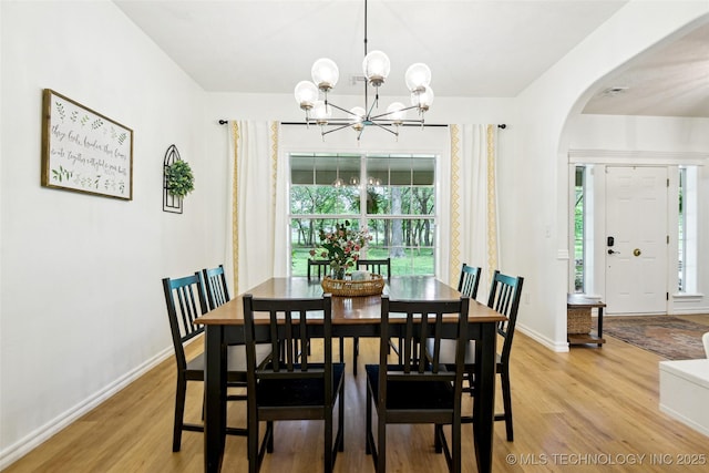 21304 S 4200th Rd, Claremore, OK 74019 - dining room featuring arched walkways, a chandelier, light wood finished floors, and baseboards