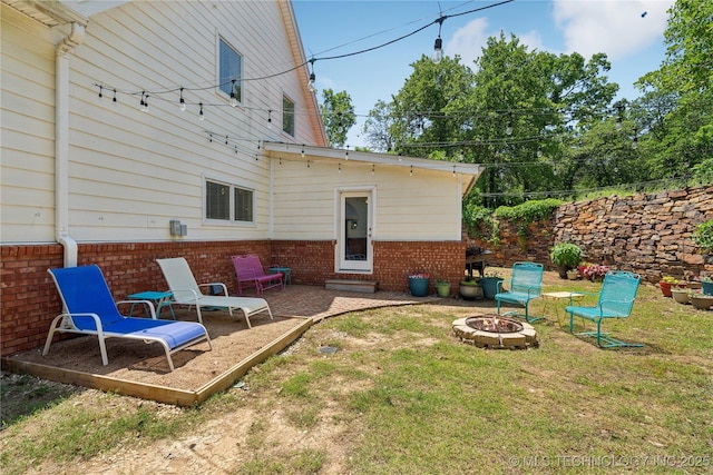5094 N 209th W Ave, Sand Springs, OK 74063 - rear view of property featuring brick siding, a fire pit, a yard, and a patio
