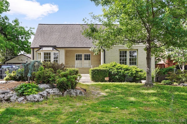 1208 E 29th St, Tulsa, OK 74114 - tudor-style house with a front lawn, a shingled roof, and brick siding