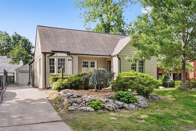 1208 E 29th St, Tulsa, OK 74114 - view of front facade with brick siding, an outbuilding, a garage, and a shingled roof
