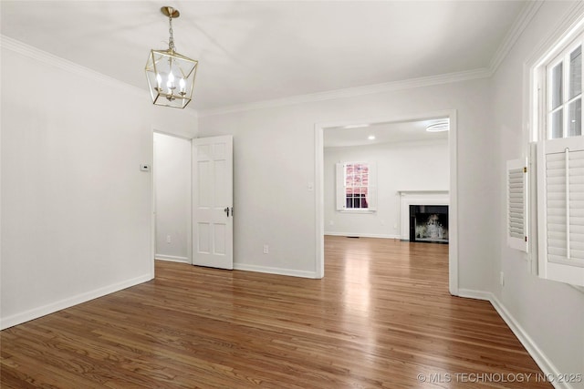1208 E 29th St, Tulsa, OK 74114 - unfurnished dining area with wood finished floors, crown molding, a chandelier, baseboards, and a fireplace