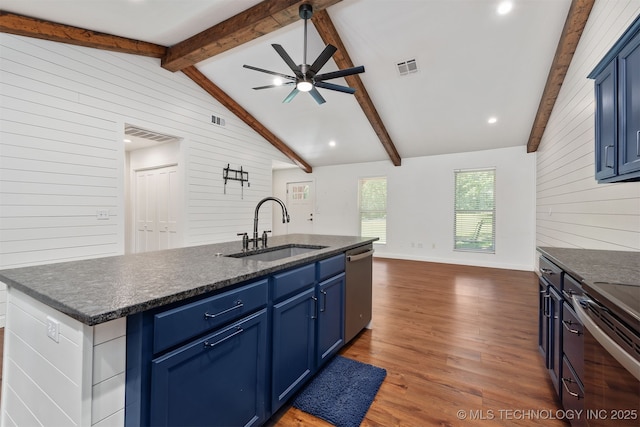 6345 W 53rd St, Tulsa, OK 74126 - kitchen featuring a sink, wooden walls, appliances with stainless steel finishes, blue cabinetry, and dark wood finished floors