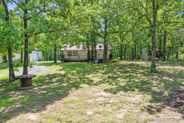 6345 W 53rd St, Tulsa, OK 74126 - view of grassy yard featuring an outdoor structure, a wooden deck, and a storage unit