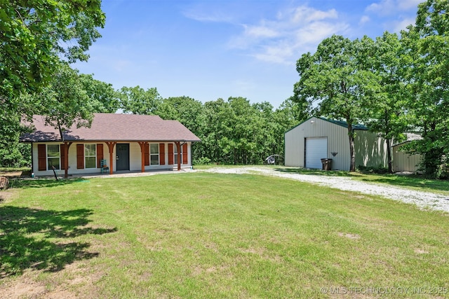 6345 W 53rd St, Tulsa, OK 74126 - view of grassy yard with driveway, a detached garage, covered porch, and an outbuilding