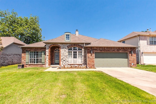view of front facade featuring a front yard, a garage, driveway, brick siding, and a chimney